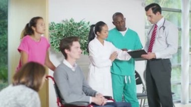 tıbbi işçiler bir hastanın notlar tartışıyor