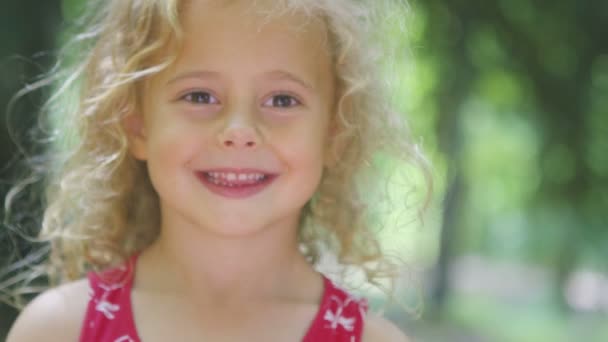 Menina se escondendo atrás de um brinquedo pinwheel — Vídeo de Stock