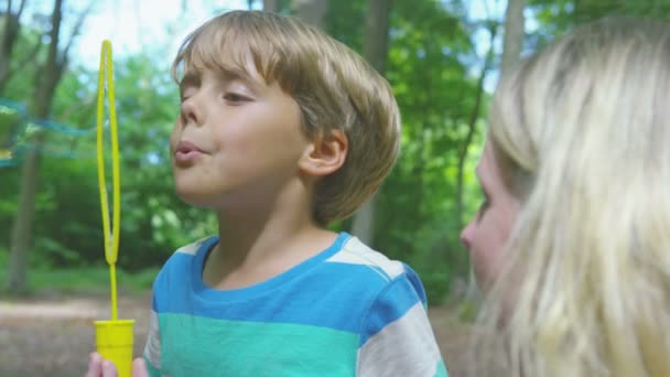 Junge spielt mit Mutter Blasen pustet — Stockvideo