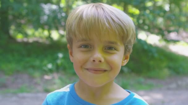 虫眼鏡で顔を引っ張る少年 — ストック動画