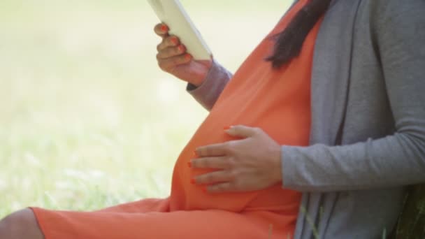 Femme enceinte se détendre avec une tablette d'ordinateur — Video