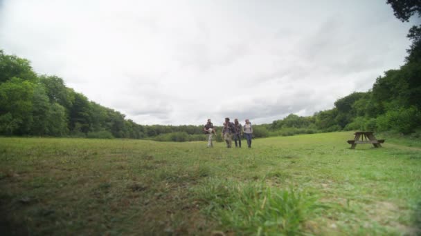 Amigos caminhando ao longo de uma trilha florestal — Vídeo de Stock