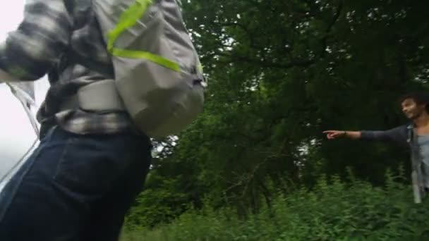 Amigos caminhando ao longo de uma trilha florestal — Vídeo de Stock