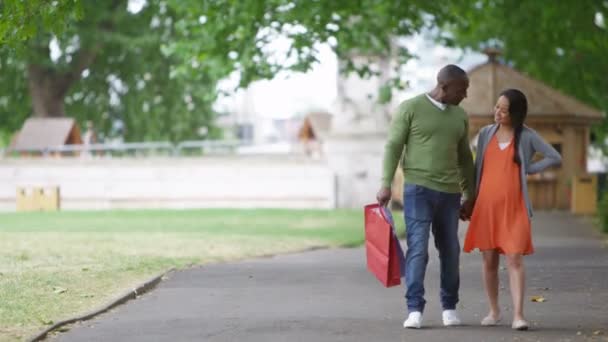 Pareja caminando con bolsas de compras en la ciudad — Vídeo de stock