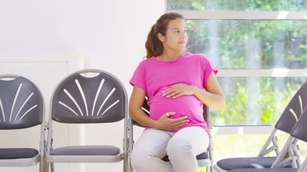 Беременная женщина массирует живот — стоковое видео
