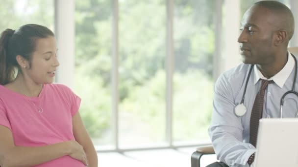 Доктор вивчає вагітну жінку в офісі — стокове відео