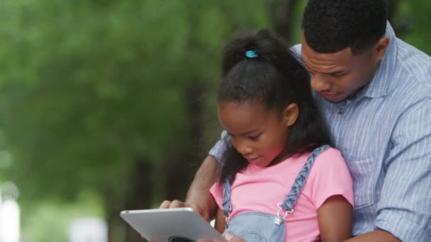 père et fille regardant tablette d'ordinateur 