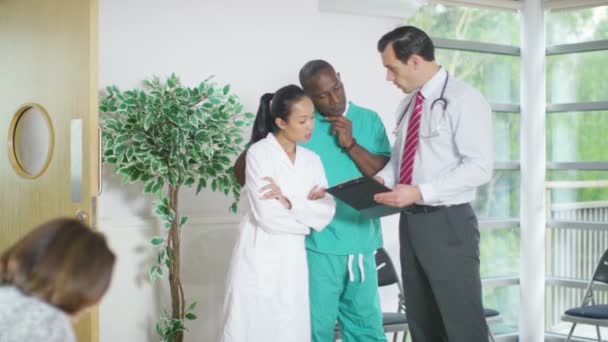 Медичні працівники обговорюють нотатки пацієнта — стокове відео