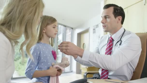 Doctor talking to mother and child in office — Stock Video