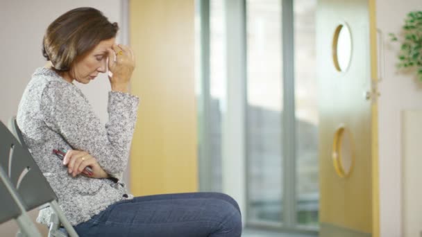 Besorgte Frau im Wartebereich eines Krankenhauses — Stockvideo