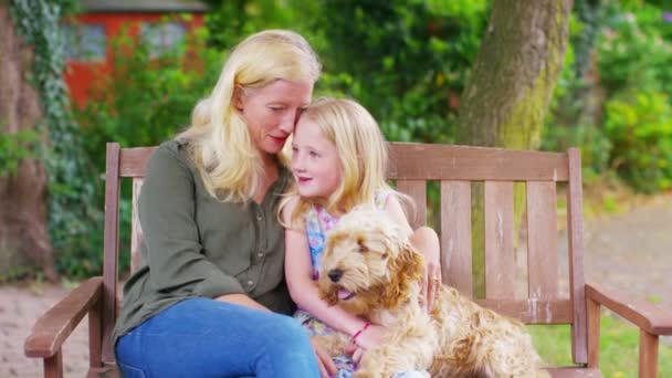 Madre e hija en el jardín con perro — Vídeo de stock