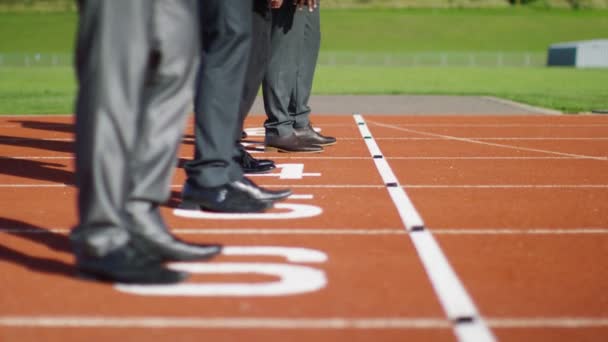 Businessmen at running track line up at starting line — Stock Video