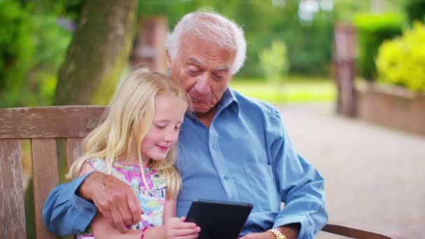 祖父と孫娘のコンピュータ タブレットを見て — ストック動画