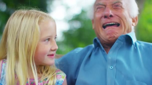 祖父と孫娘の庭でおしゃべり — ストック動画
