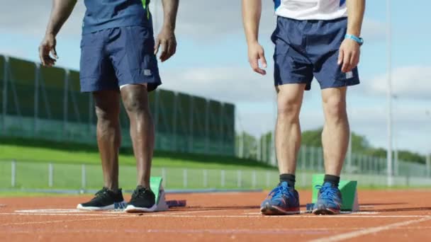 Atletas se ponen en posición en pista de atletismo — Vídeo de stock