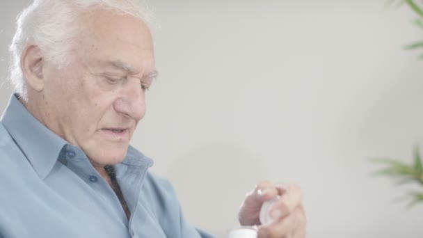 Äldre herre tittar på medicinering — Stockvideo