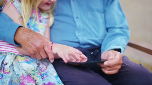 Дедушка и внучка смотрят на планшет — стоковое видео