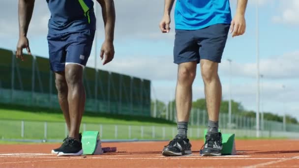 Atletas se ponen en posición en pista de atletismo — Vídeos de Stock