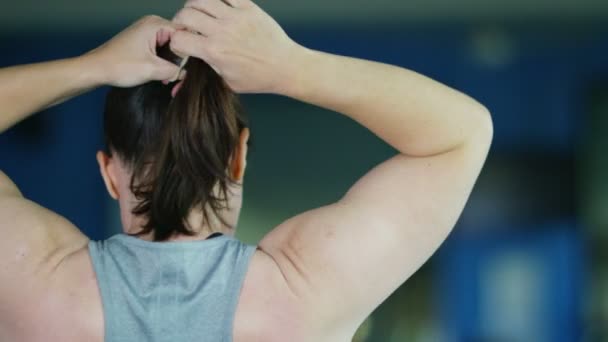 Mujer atándose el pelo — Vídeos de Stock