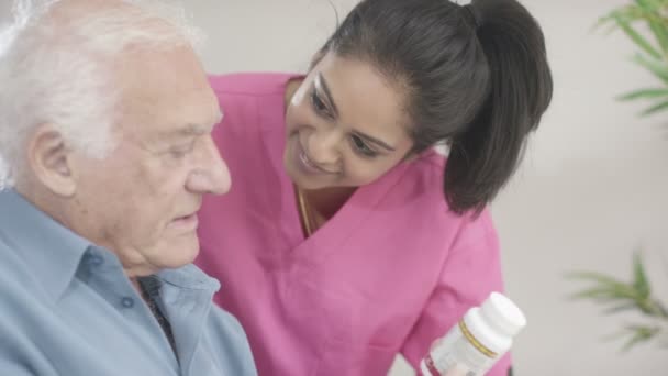 Krankenschwester kümmert sich um älteren Herrn — Stockvideo