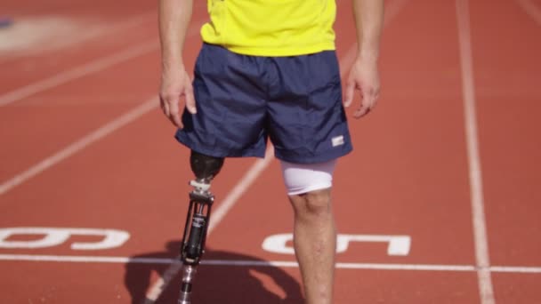 Спортсмен с протезной ногой на беговой дорожке — стоковое видео