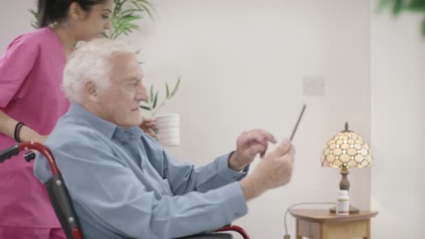 Krankenschwester hilft Gentleman, Tablette zu benutzen — Stockvideo