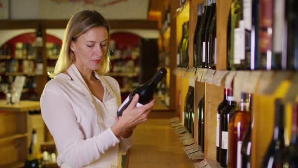 Покупець стоїть на полицях пляшок — стокове відео