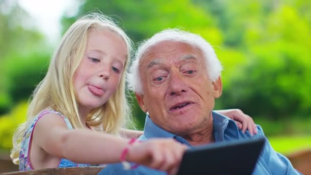 Grandfather and granddaughter looking at computer tablet — Stock Video