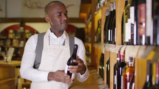 Affärsinnehavaren stå vid hyllorna i flaskor — Stockvideo