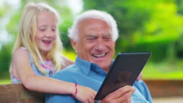 Дід і онука дивляться на планшет комп'ютера — стокове відео