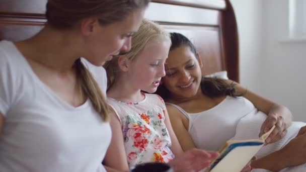 Гей женщина пара чтение с дочерью — стоковое видео