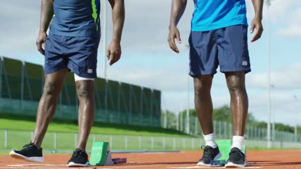 Спортсмены занимают позиции на беговой дорожке — стоковое видео