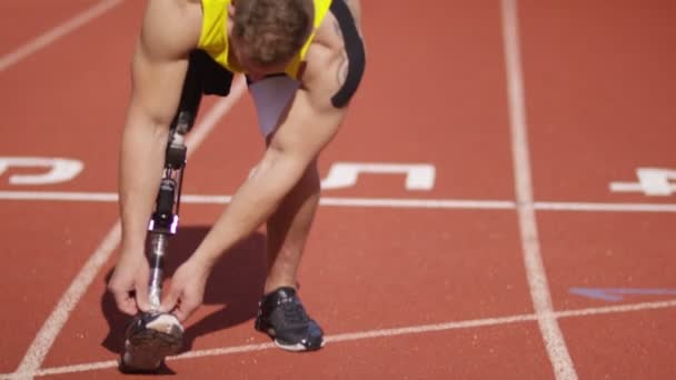 Спортсмен налаштовує свою протезну ногу — стокове відео