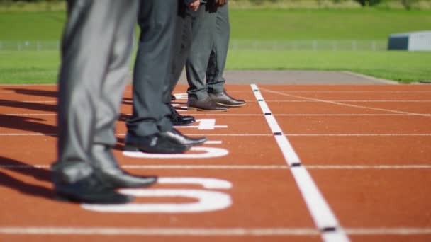 Businessmen at running track line up at starting line — Stock Video