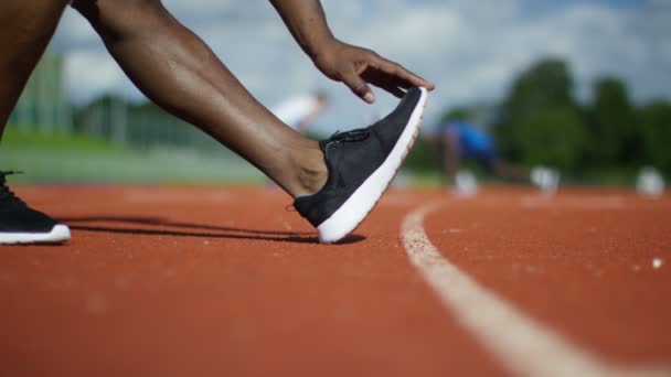 Atleta che si allunga sulla pista da corsa — Video Stock