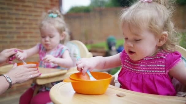 Mother feeding toddler twins — Stock Video