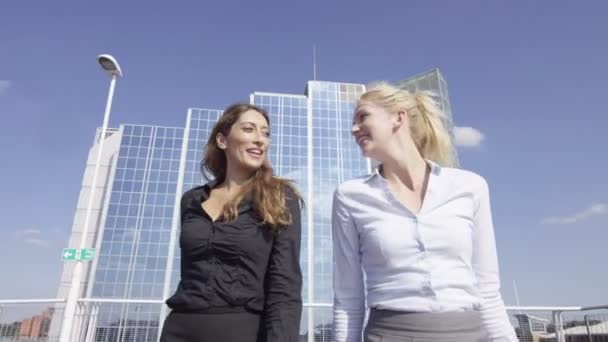 Mujeres de negocios charlando mientras caminan al aire libre — Vídeo de stock