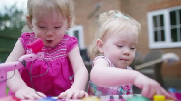 Toddler twins playing with musical toy — Stock Video