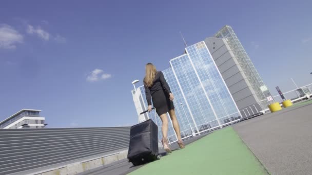 Бізнес-леді, що йде з багажем в аеропорту — стокове відео