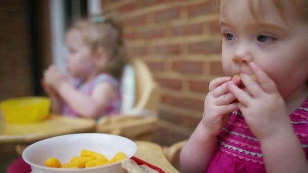 Δίδυμα μικρό παιδί που τρώει σνακ — Αρχείο Βίντεο