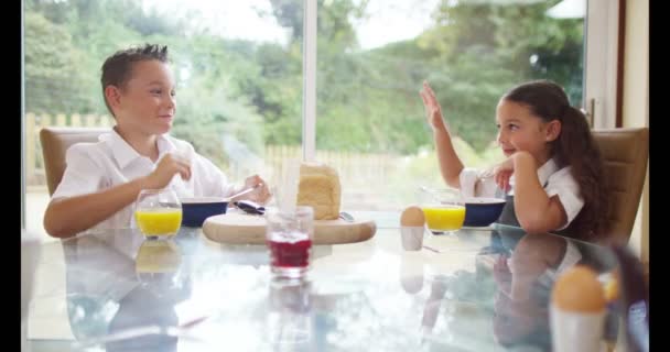 Hermano y hermana comiendo en el desayuno — Vídeos de Stock
