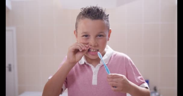 Pojke i badrum rengöring hans tänder — Stockvideo