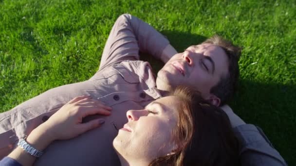 Paar legt sich ins Gras — Stockvideo