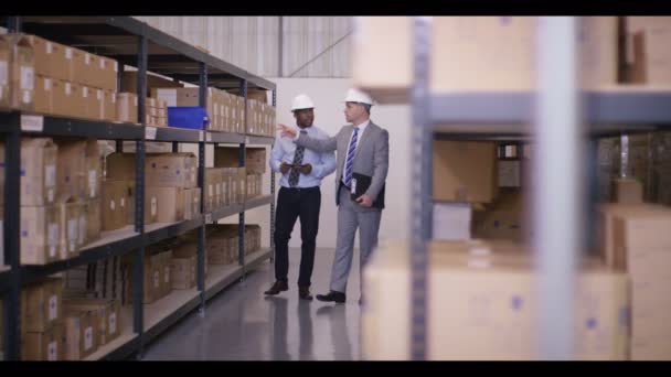 Бізнесмени йдуть через промисловий склад — стокове відео