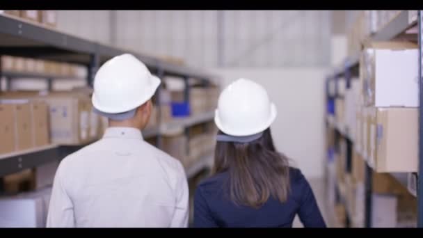 Man and woman  walk through warehouse — Stock Video