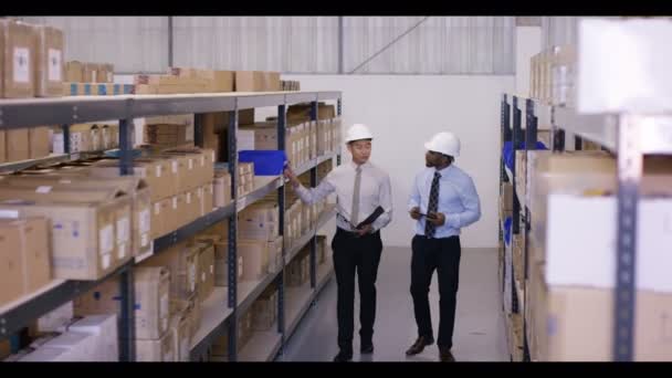 Businessmen walk through industrial warehouse — Stock Video