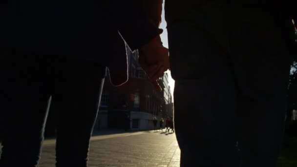 Pareja cogida de la mano caminar por la ciudad — Vídeos de Stock