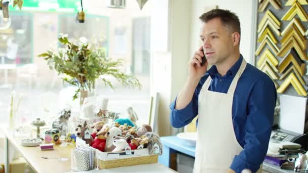 Propietario de un negocio hace una llamada telefónica — Vídeos de Stock