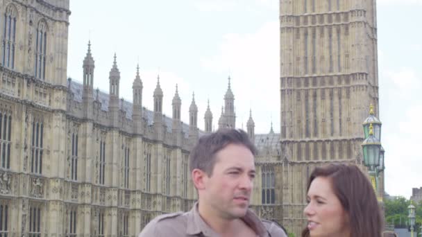 Пара, стоящая перед зданиями парламента — стоковое видео
