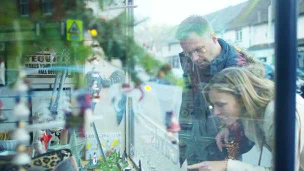 Пара смотрит в окно магазина — стоковое видео
